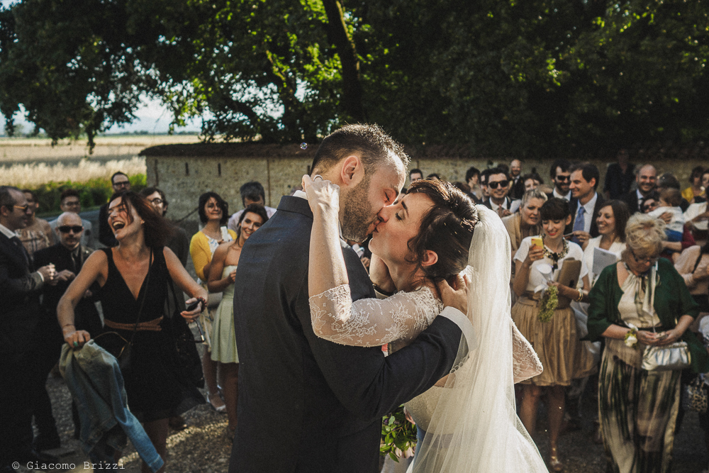 Bacio degli sposi fuori la chiesa matrimonio Castello di Paderna a Pontenure
