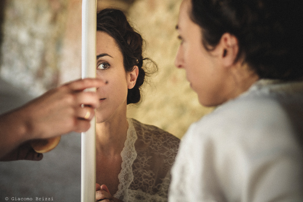 Foto di dettaglio della sposa riflessa nello specchio fotografo matrimonio Castello di Paderna a Pontenure
