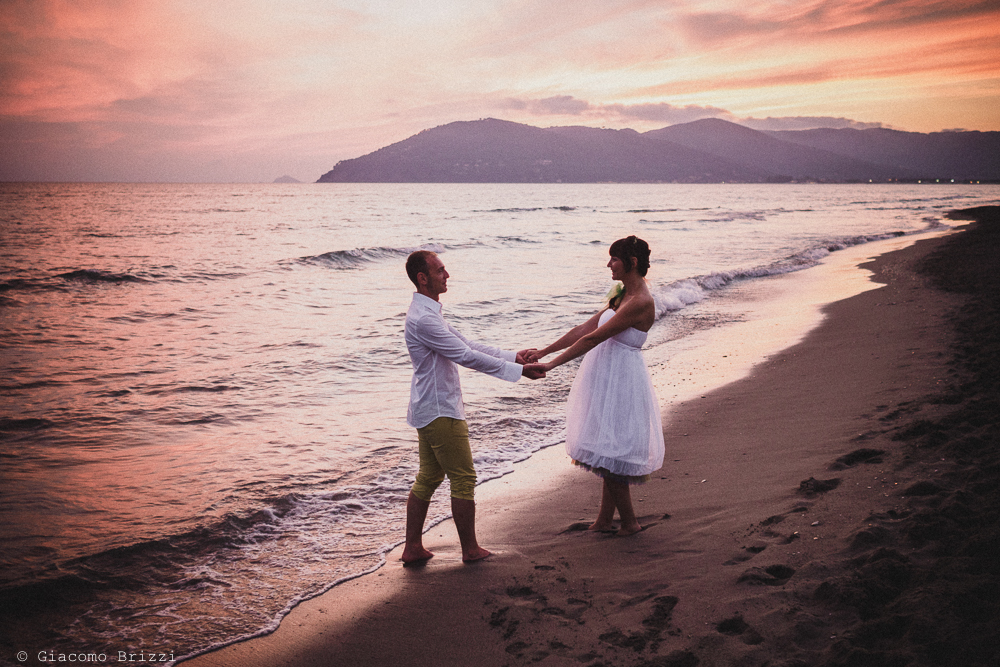 Gli sposi si tengono per mano in riva al mare, fotografo matrimonio Sarzana, Liguria