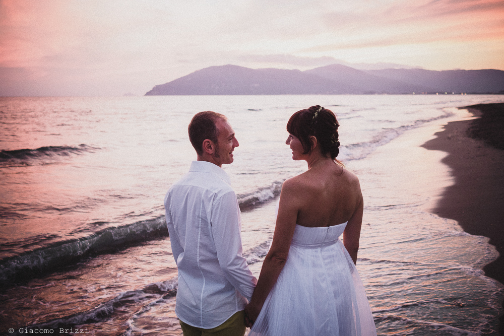 Gli sposi di spalle in riva al mare, fotografo matrimonio Sarzana, Liguria