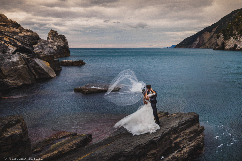 Gli sposi fotografati sugli scogli con il golfo ligure sullo sfondo, fotografo matrimonio ricevimento hotel europa, lerici