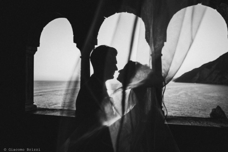 Foto in controluce degli sposi sotto i portici, fotografo matrimonio ricevimento le terrazze, portovenere