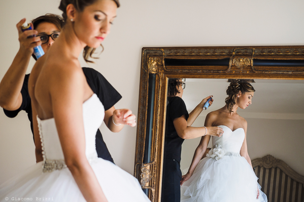 La sposa durante i preparativi, riflessa nello specchio, fotografo matrimonio ricevimento Sunset, Forte dei Marmi