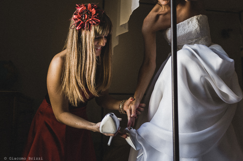 La sposa calza le scarpe, nella preparazione per il matrimonio, fotografo matrimonio ricevimento villa fanini, Lucca