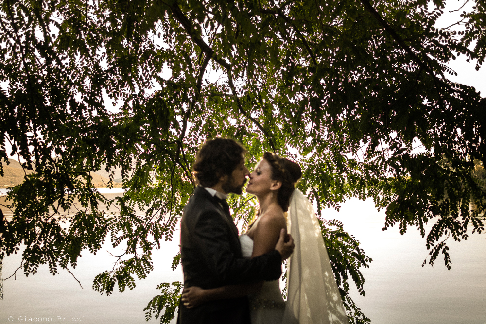 Ritratto in controluce, bacio tra gli sposi, fotografo matrimonio ricevimento Villa Orlando, Versilia