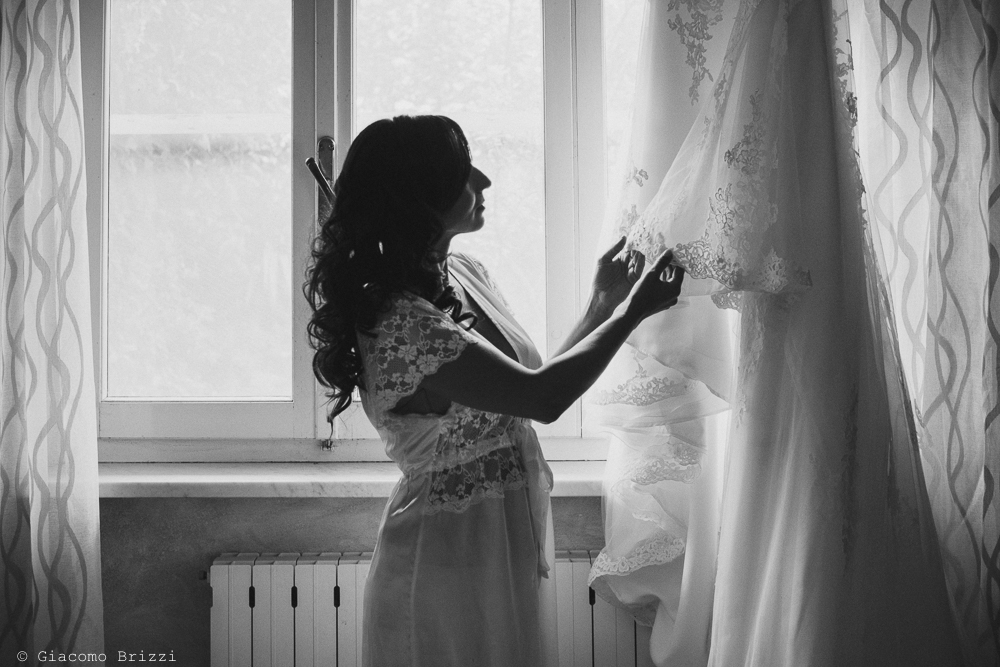 Foto in controluce la sposa ammira il suo abito fotografo ricevimento valle di badia
