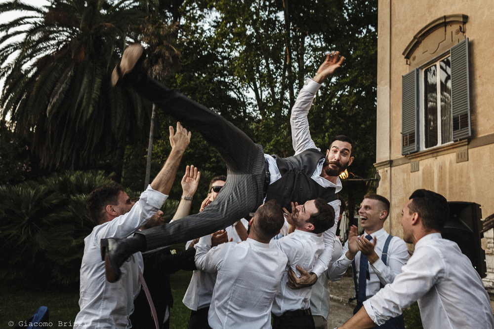 Gli invitati lanciano lo sposo in aria, matrimonio San Giuliano Terme, Pisa. Giacomo Brizzi Fotografo